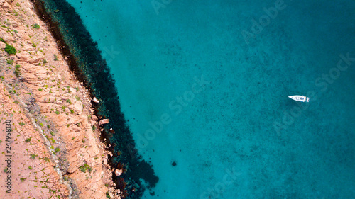 Sand, rock, and sea patterns on cristal clear waters.