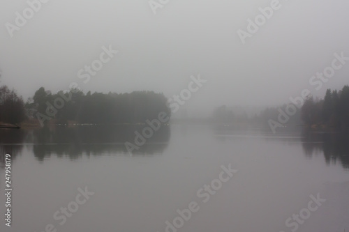 Autumn dark day landscape of Kymijoki river waters in fog. Finland, Kymenlaakso, Kouvola.