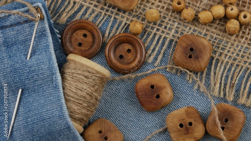 Decorative composition with wooden buttons and accessories for sewing on denim and burlap