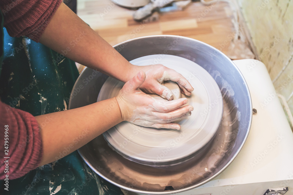 Child hands working with clay on pottery wheel Child hands working with clay on pottery wheel