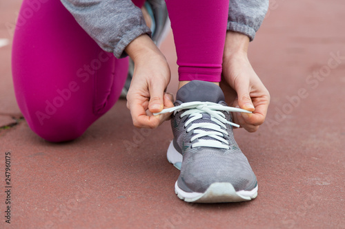 Close-up of runner tying lace of sport shoe