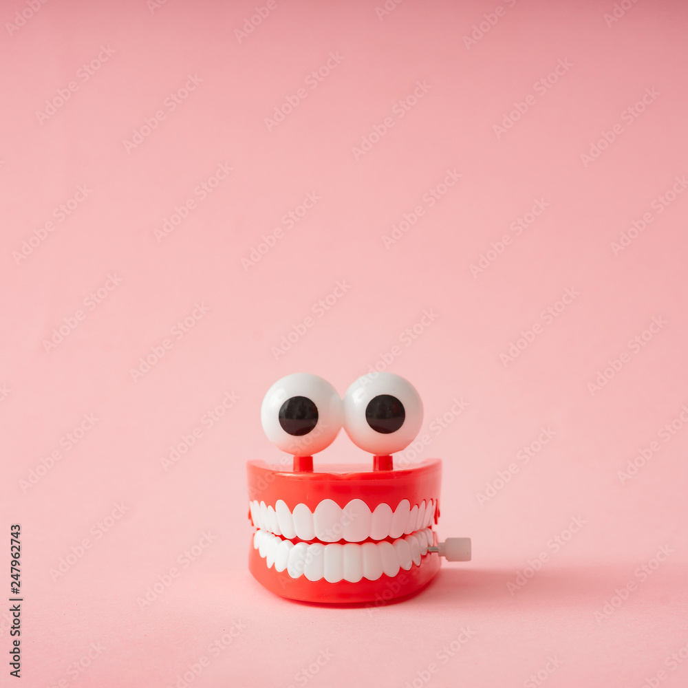 Plastic toy teeth against pastel background. Abstract minimal composition. - obrazy, fototapety, plakaty 