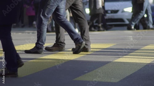 Slow motion shot of groups of people crossing a busy shopping street in Zürich city center in sunny winter at daytime.