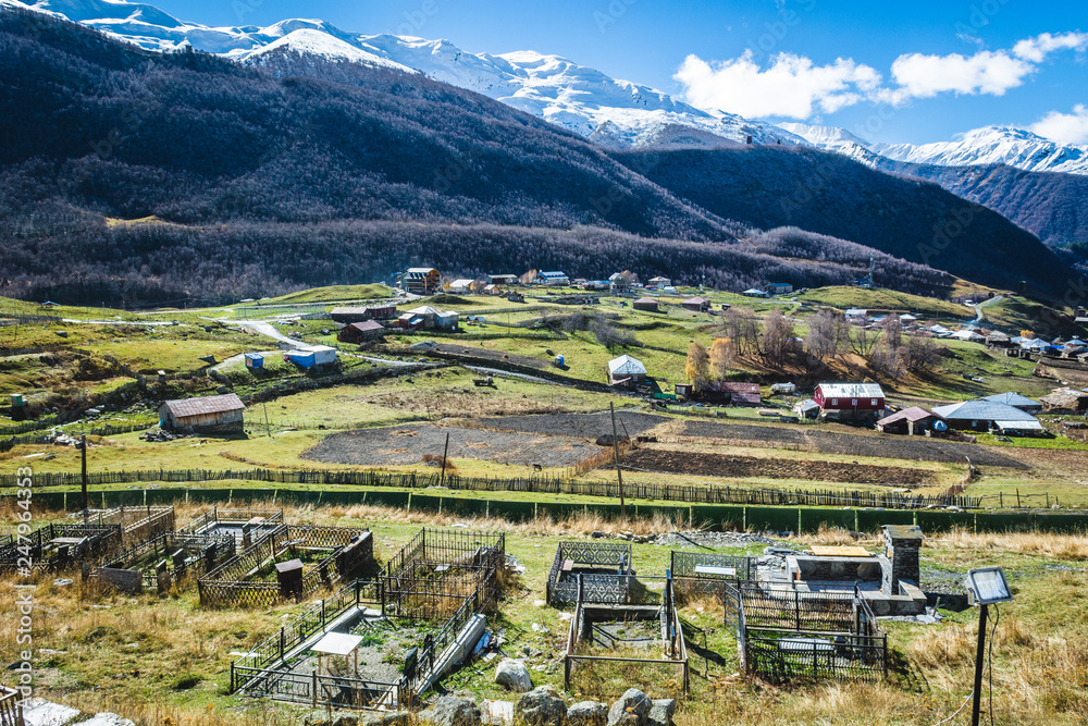Picturesque landscape of aged Georgian rural community Ushguli with Typical Svaneti defensive tower houses in valley of beautiful mountains with snowy peaks, UNESCO World Heritage Site