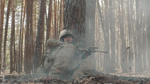 A young soldier is very afraid during a battle in the forest