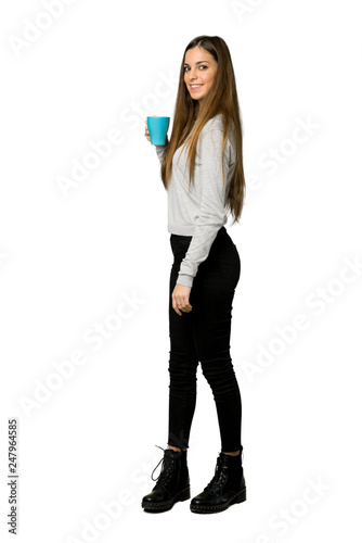 Full-length shot of young girl holding a hot cup of coffee on isolated white background © luismolinero