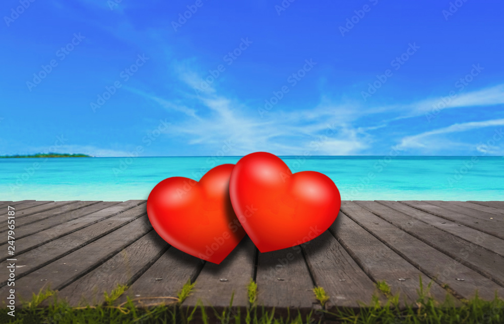 Fototapeta premium Red heart on wooden floor, bridge with sea as background.