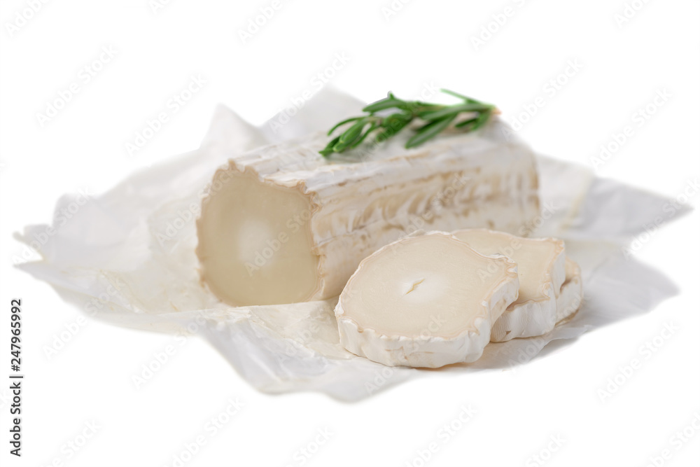 Stick of a goat cheese on paper on the white background. Stick of a goat cheese on paper on the white background.