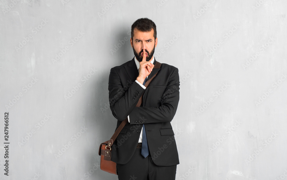 Businessman with beard showing a sign of silence gesture putting finger in mouth Businessman with beard showing a sign of silence gesture putting finger in mouth