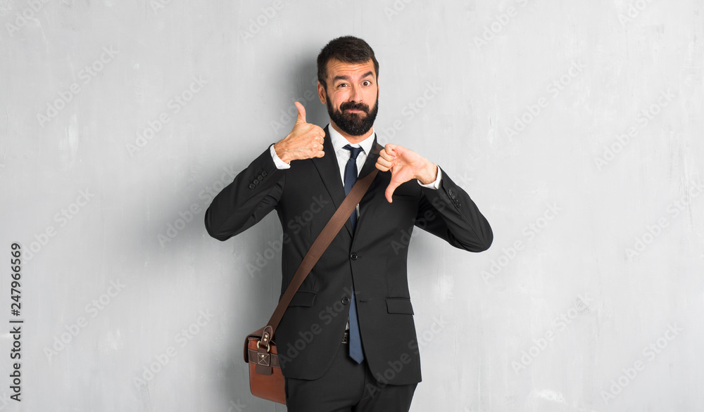 Businessman with beard making good-bad sign. Undecided between yes or not Businessman with beard making good-bad sign. Undecided between yes or not