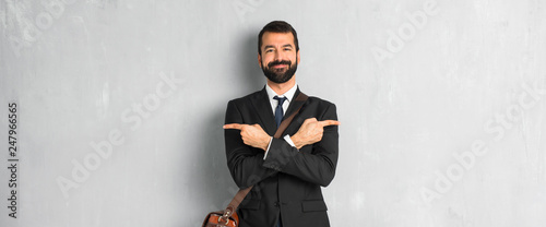 Businessman with beard pointing to the laterals having doubts