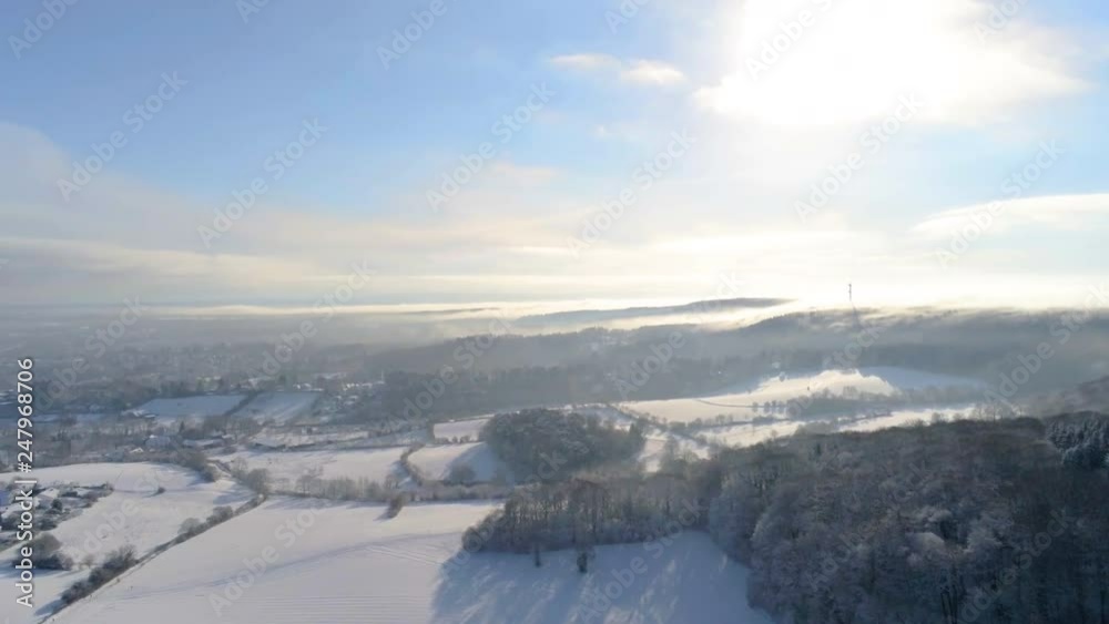 Panning motion over snow covered winter wonderland in German Eifel close to Aachen with drone over meadows and forrest Panning motion over snow covered winter wonderland in German Eifel close to Aachen with drone over meadows and forrest