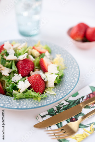 Salat with cheese and strawberries on plate