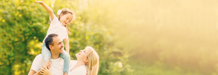 Happy family: mother father and child daughter on nature on sunset