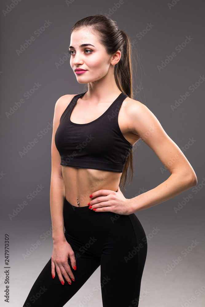 Portrait beautiful young athletic girl on a gray background Portrait beautiful young athletic girl on a gray background