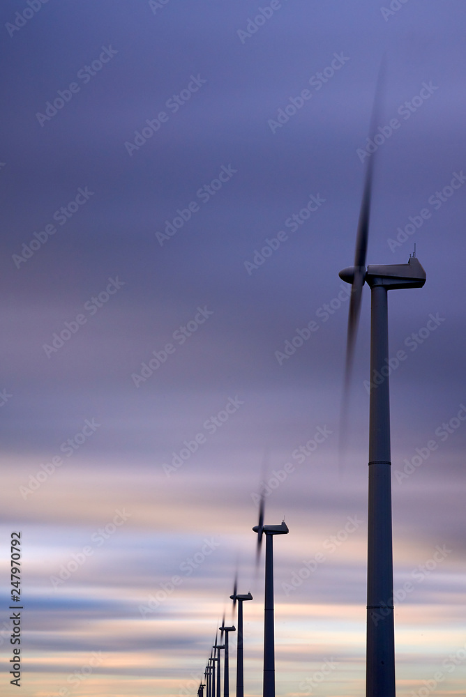 Obraz premium Alternative clean energy is a must these days. Here we see wind parks with many wind turbines in a landscape
