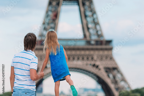 Little cute girl and her father in Paris near Eiffel Tower during summer french vacation