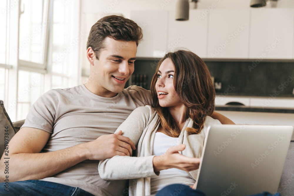 Smiling young couple relaxing on a couch at home