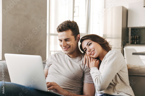 Smiling young couple relaxing on a couch at home