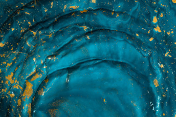 Abstract paint texture art. Natural luxury. Blue paint with gold glitter powder. Marble background.