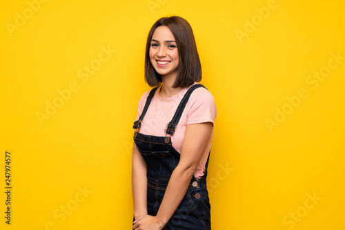 Young woman over yellow wall Happy and smiling