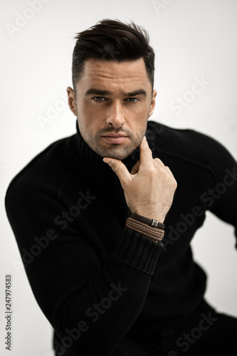 Portrait of handsome man in black turtleneck jumper isolated on white background © kiuikson