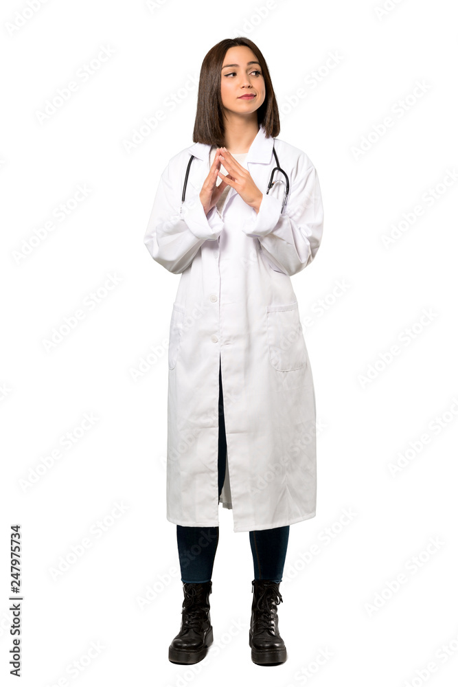 A full-length shot of a Young doctor woman scheming something over isolated white background A full-length shot of a Young doctor woman scheming something over isolated white background