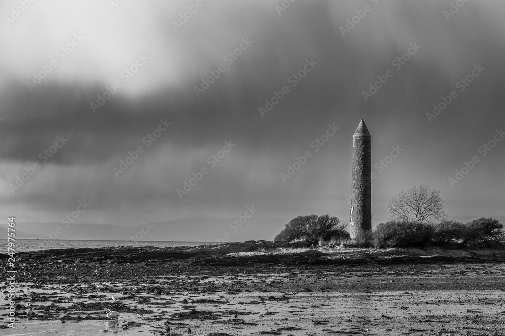 A Black & White Image of Largs Foreshore and the Pencil Monument Commemorating the Viking Battle of Largs in 1263. A Heavy Rain Cloud about to Decend.