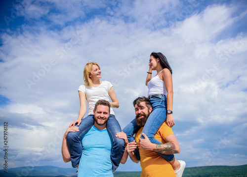 The fun begins. Loving couples enjoy fun together. Playful couples in love smiling on cloudy sky. Happy men piggybacking their girlfriends. Loving couples having fun activities outdoor