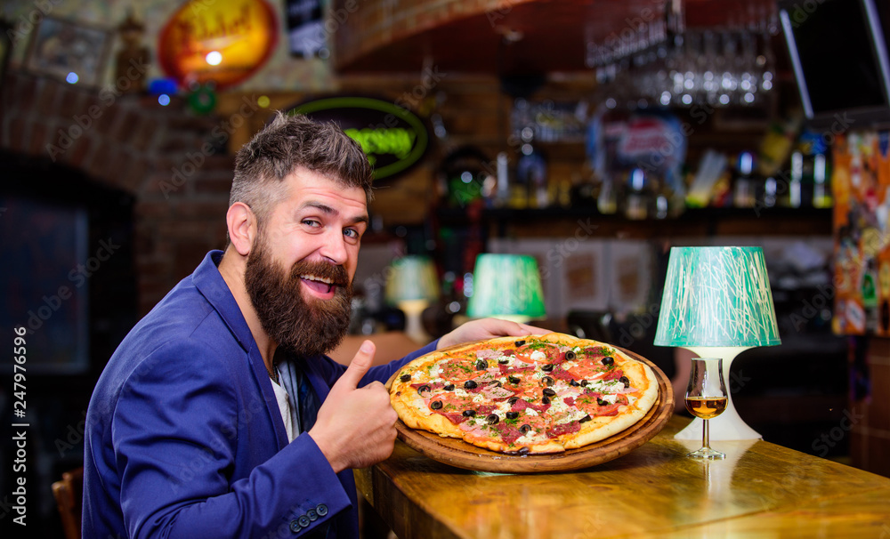 Man received delicious pizza. Enjoy your meal. Cheat meal concept. Pizza favorite restaurant food. Fresh hot pizza for dinner. Hipster hungry eat italian pizza. Hipster client sit at bar counter