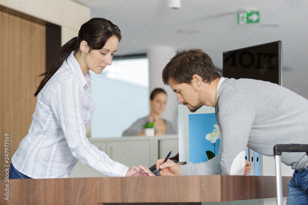 young man and woman talking over a desk young man and woman talking over a desk