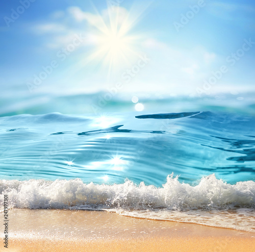 Fototapeta Naklejka Na Ścianę i Meble -  Summer landscape with sea surf, nature of tropical beach with rays of sun light. Golden sand beach, wave sea water, blue sky with white clouds. Copy space, summer vacation concept.