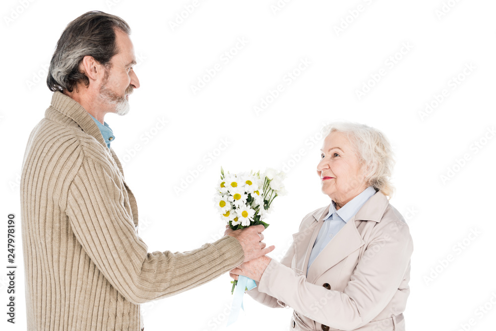 cheerful senior man giving flowers to happy woman isolated on white cheerful senior man giving flowers to happy woman isolated on white