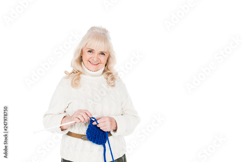 happy senior woman standing and knitting isolated on white