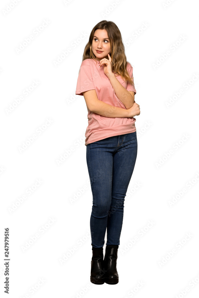 A full-length shot of a Teenager girl with pink sweater thinking an idea pointing the finger up on isolated white background A full-length shot of a Teenager girl with pink sweater thinking an idea pointing the finger up on isolated white background