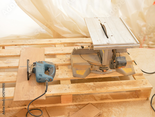 Cropped shot of a wood cutting machine in a workshop and another manual saw