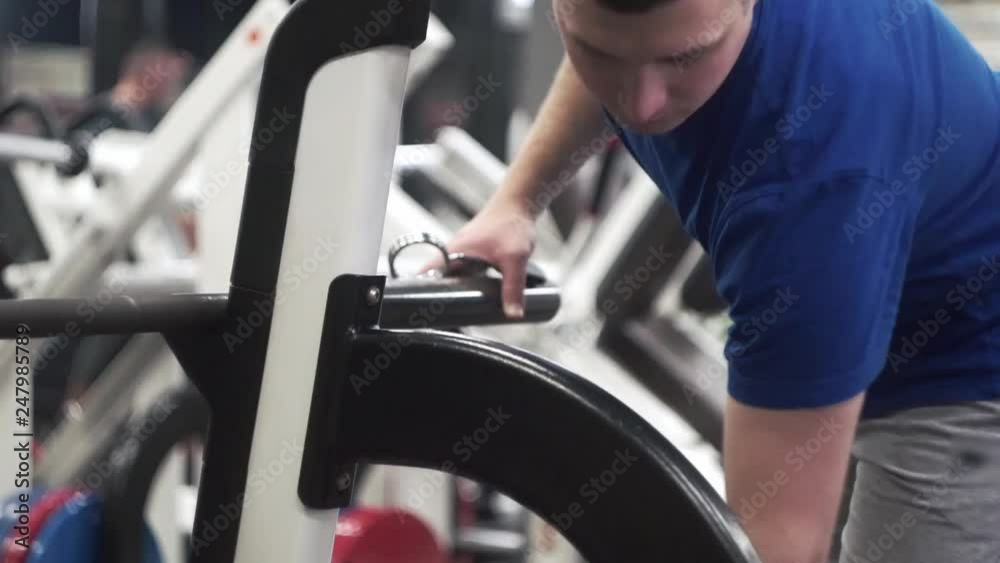Newbie adding weigh plates to olympic bar between sets of push press chest sets. Newbie adding weigh plates to olympic bar between sets of push press chest sets.