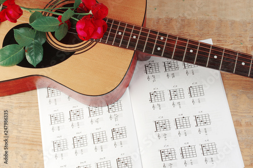 Acoustic guitar and table of chord. Learning to play the guitar