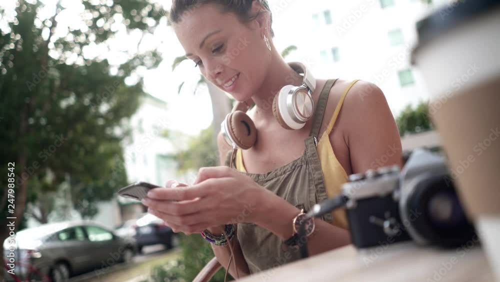Stylish young woman texting outdoors on café terrace Stylish young woman texting outdoors on café terrace