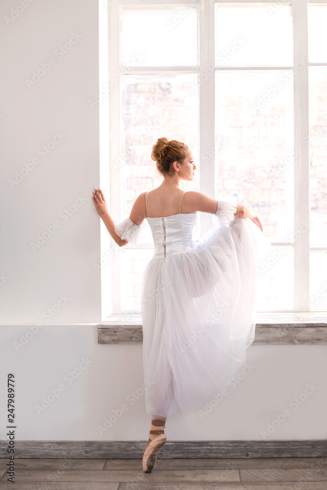 Young ballerina is stretching on dance hall. Young ballerina is stretching on dance hall.