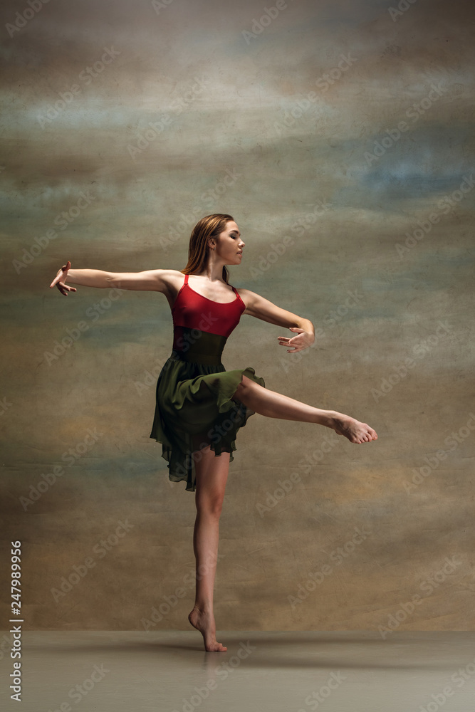 The young woman dancing in contemporary stile on gray background. Modern female dancer at studio. Elegance, grace and performance concept