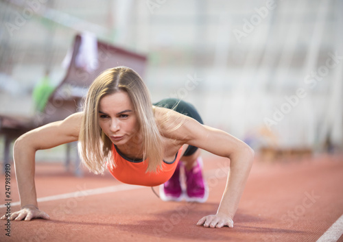 Young fit athletic woman doing push ups