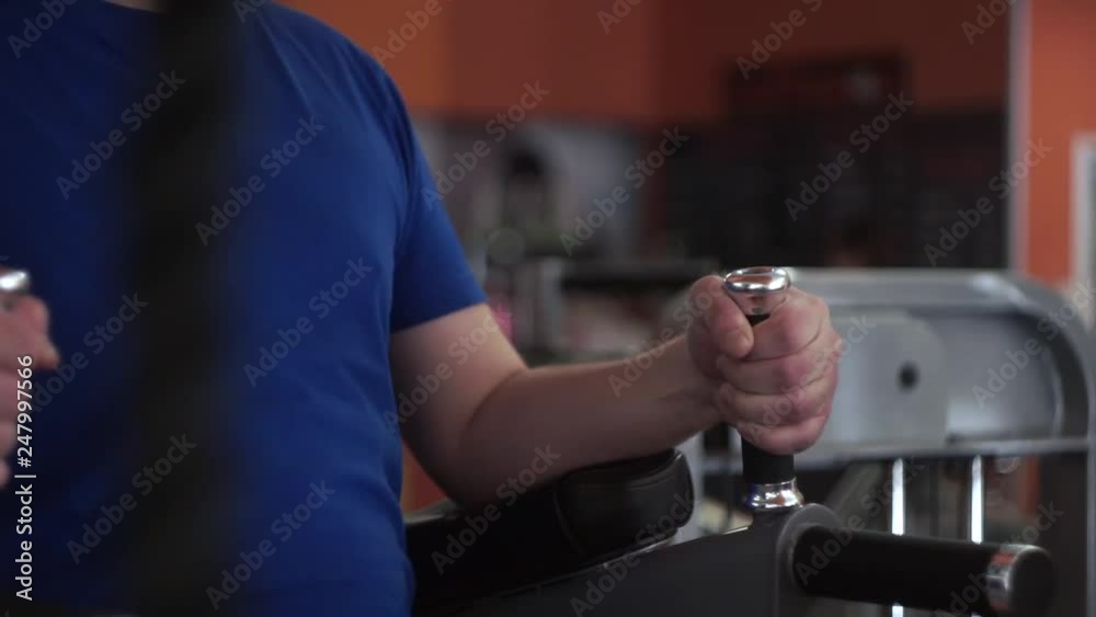 Male abs press workout. Torso medium shot in the gym. Shallow depth of field and denim outfit