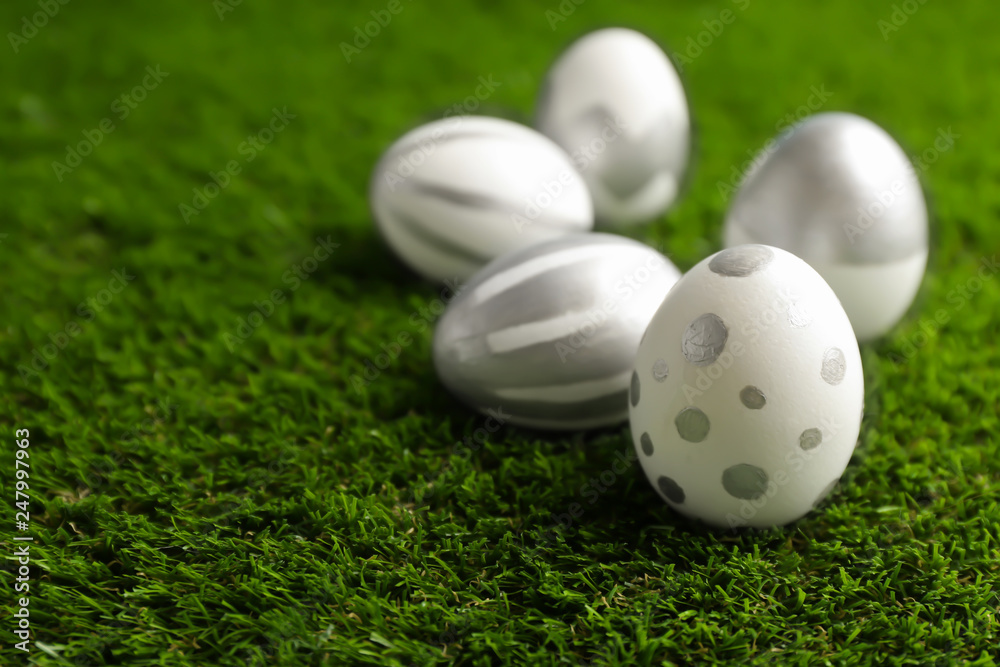 Traditional painted Easter eggs on green lawn, space for text Traditional painted Easter eggs on green lawn, space for text