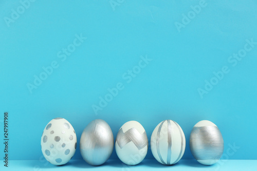 Painted Easter eggs on color background, space for text. Stylish design
