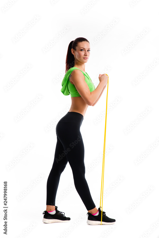 Athletic girl working with resistance band. Photo of attractive latin girl with beautiful athletic body isolated on white background.