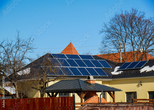 Photovoltaic solar panels on residentual house rooftop, blue sky background. photo