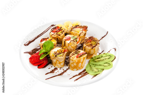 Tasty roll of pancakes with fruits and berries isolated on White Background. Fresh Homemade Crepes