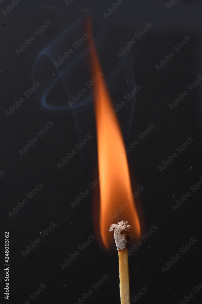 Burning match over black background Burning match over black background