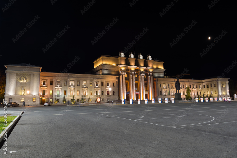 The night picture of beautifully lit opera theater in Samara against the background of the black sky and the moon. The night picture of beautifully lit opera theater in Samara against the background of the black sky and the moon.